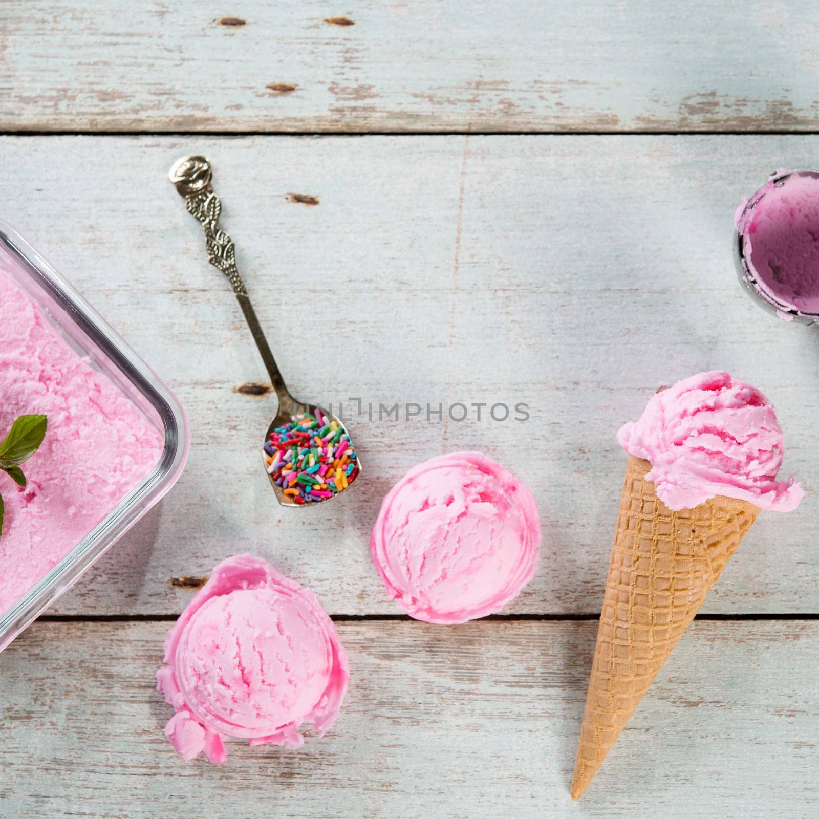 Top view strawberry ice cream waffle cone on wooden background.