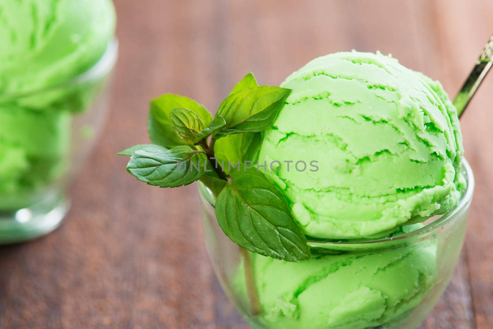 Pistachio ice cream in cup on dining table.