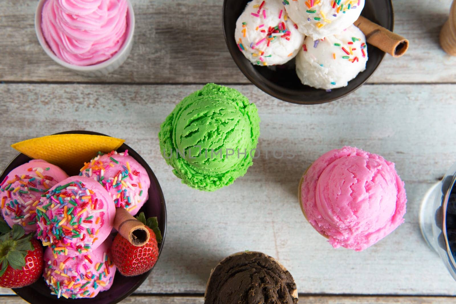 Top view strawberry, matcha and vanilla ice cream in bowl on white rustic wooden background.