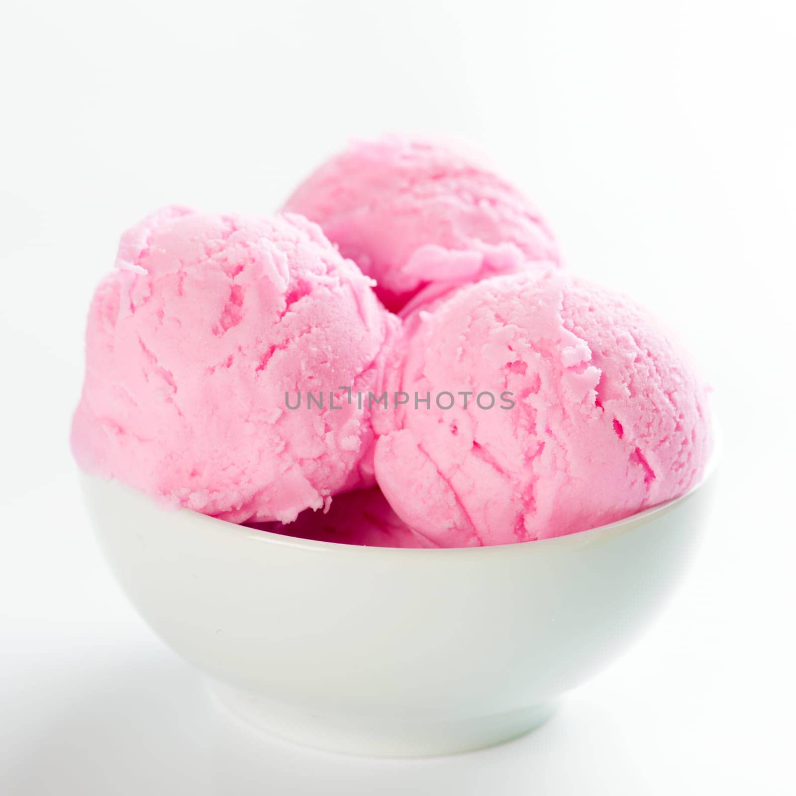 Strawberry ice cream in bowl on white background.