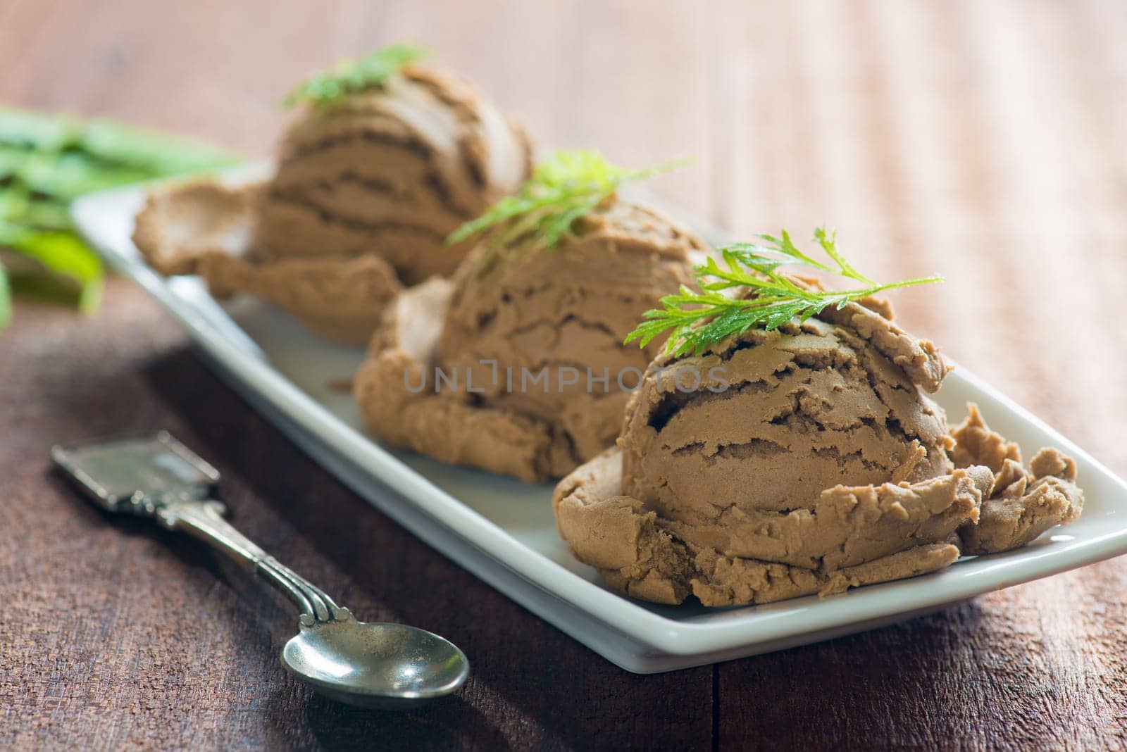 Chocolate ice cream in plate on dark wood background.