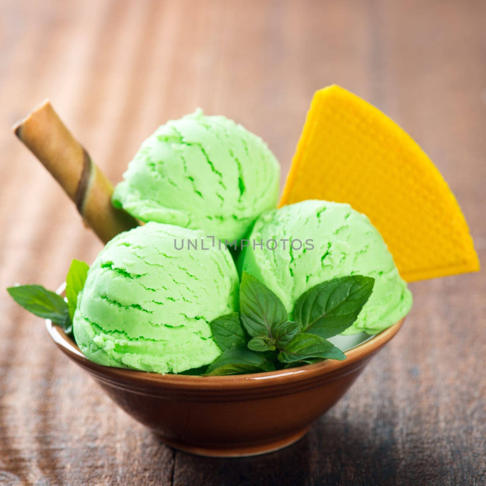 Bowl of mint yogurt ice cream on wooden background.