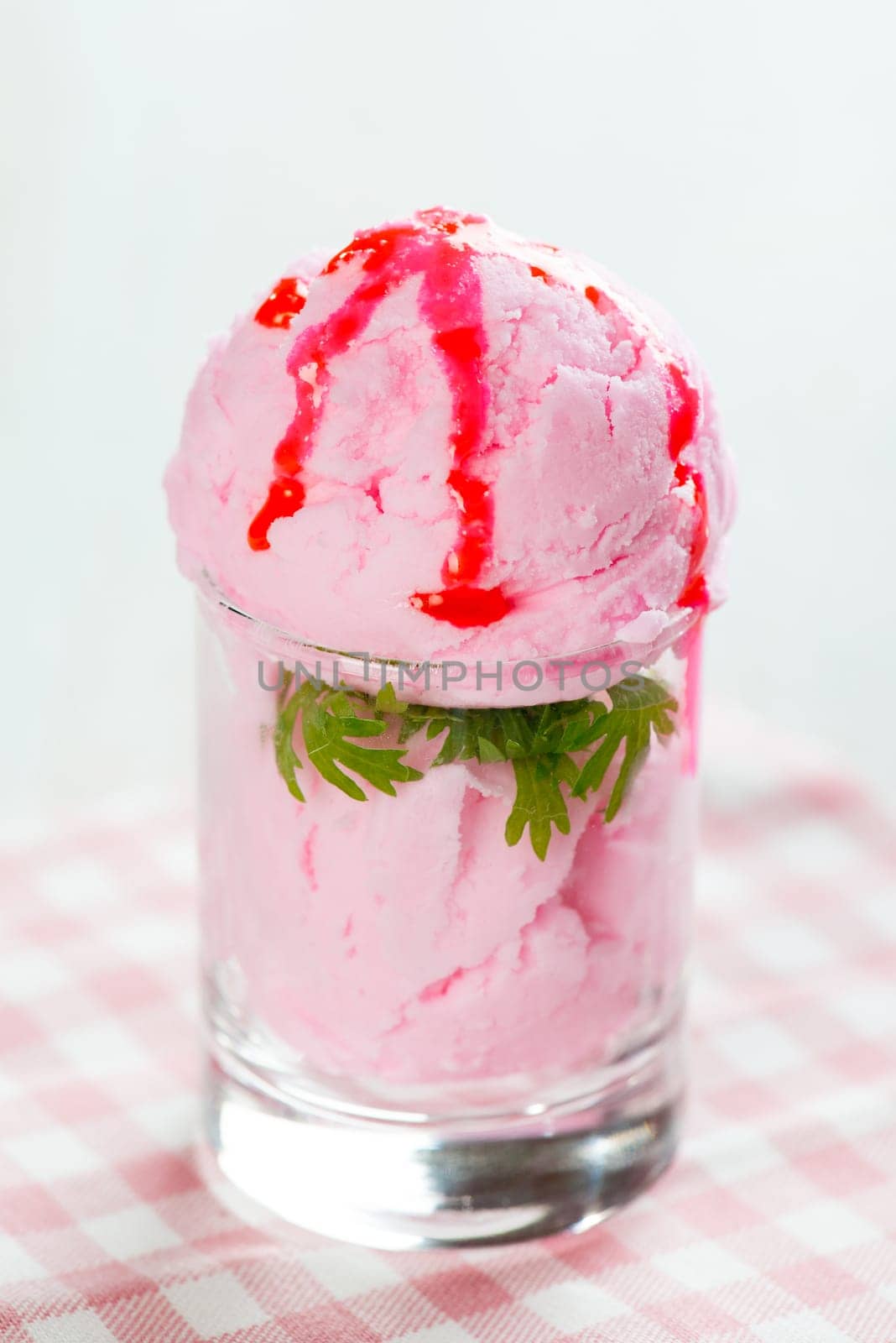 Strawberry ice cream cup on white wooden background.