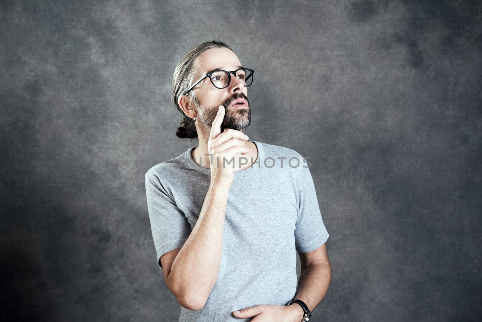 young bearded man with glasses is reflecting