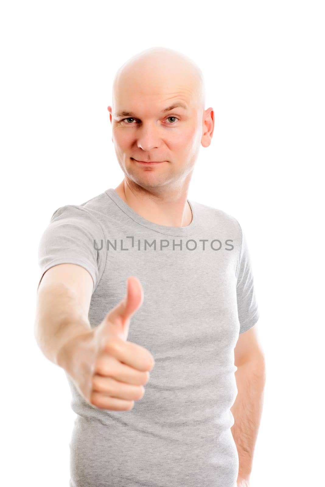 young man with bald head and thumb up is looking friendly in to the camera