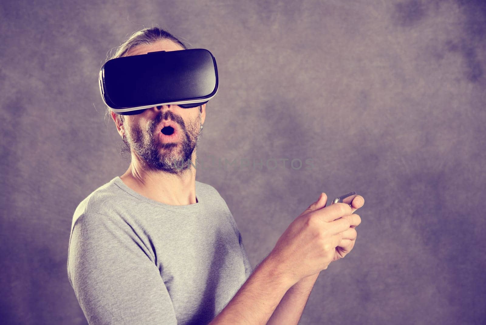young man with virtual reality glasses looking surprised