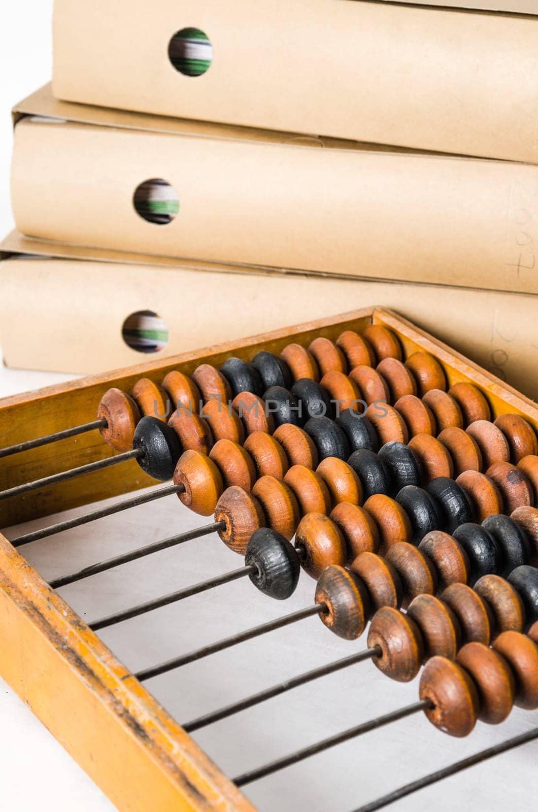 Old abacus and folders with documents, close-up isolated on white