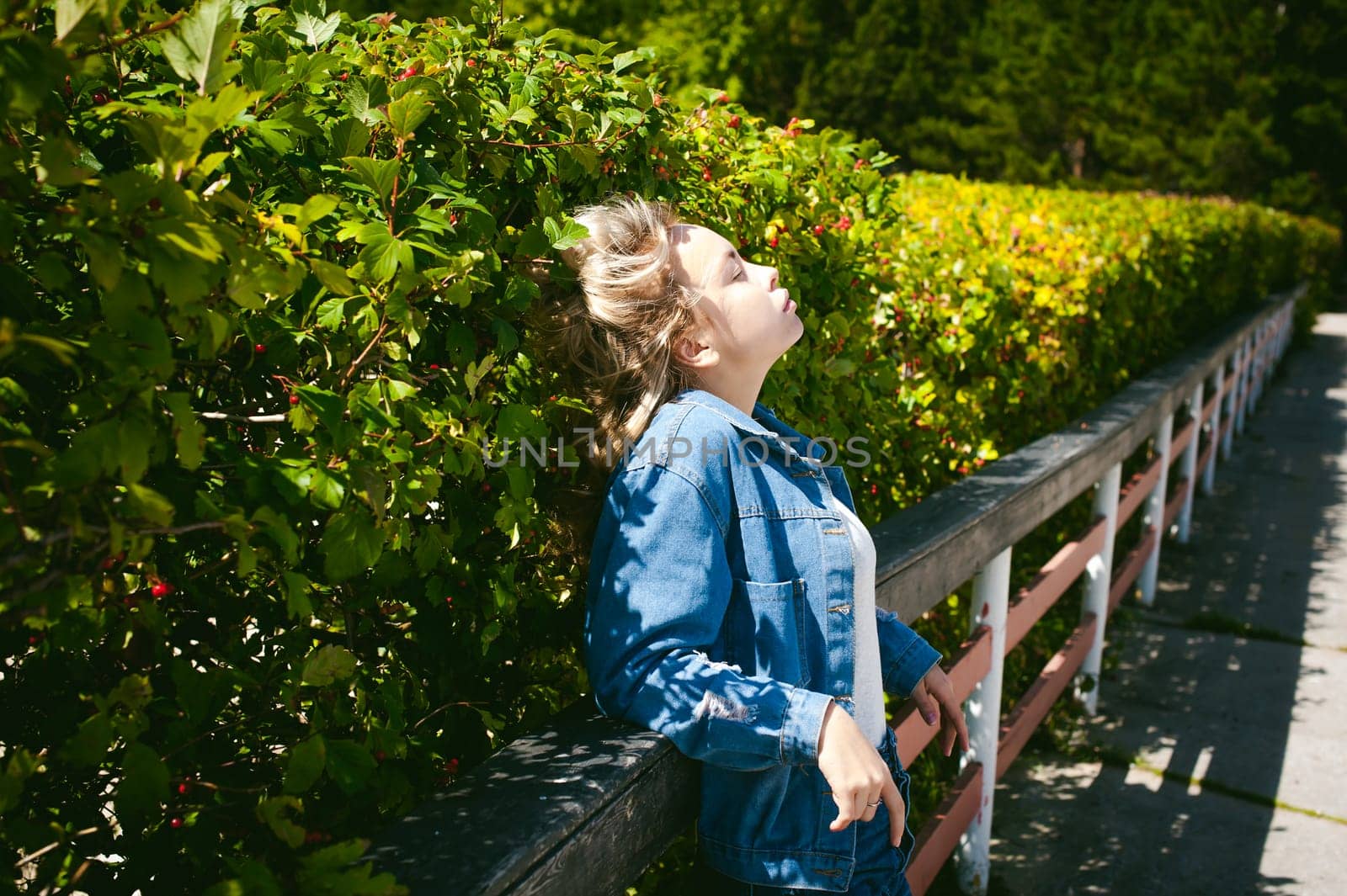 young beautiful woman in jeans clothes outdoors. portrait of a girl with freckles on her face, stylish girl on a sunny summer autumn day.