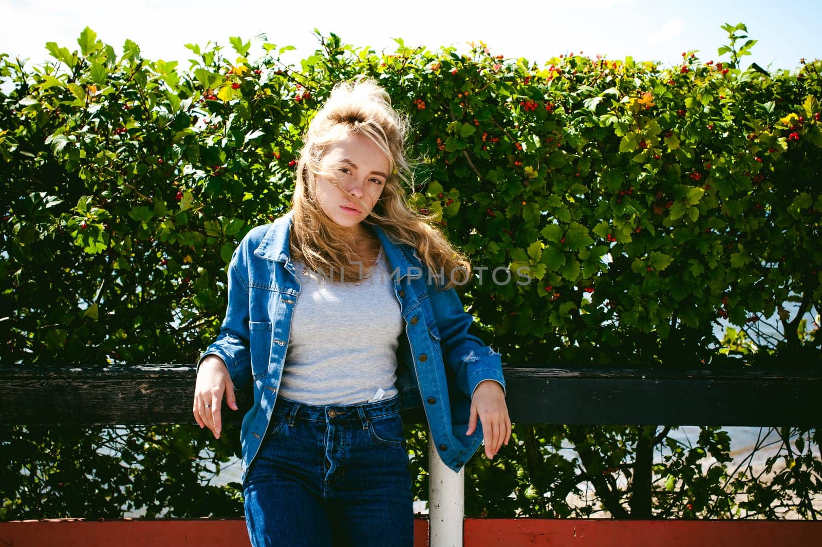 young beautiful woman in jeans clothes outdoors. portrait of a girl with freckles on her face, stylish girl on a sunny summer autumn day.