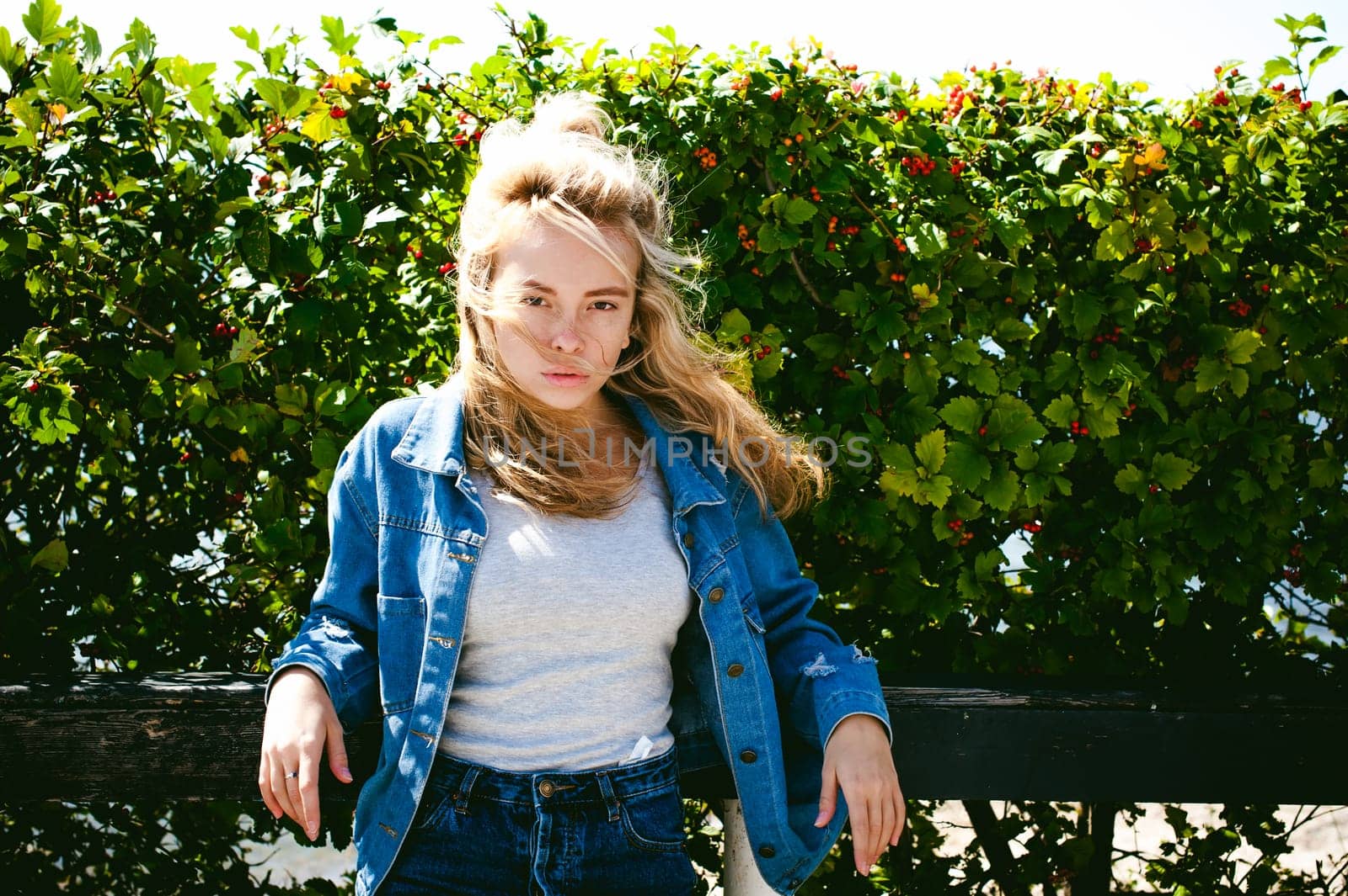 young beautiful woman in jeans clothes outdoors. portrait of a girl with freckles on her face, stylish girl on a sunny summer autumn day.