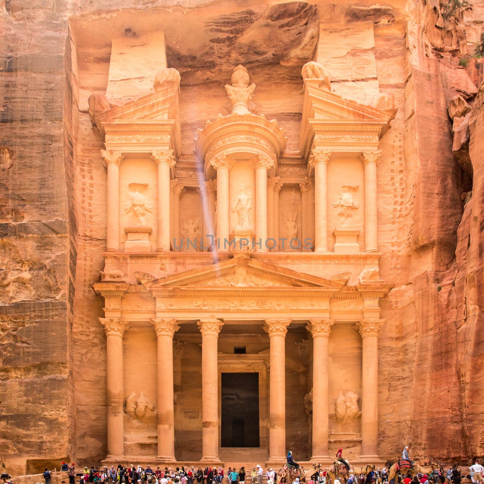 PETRA, JORDAN - APRIL 25, 2016: People near al-Khazneh temple (The Treasury) in ancient Petra. Rock-cut town Petra was established about 312 BC as the capital city of the Arab Nabataean