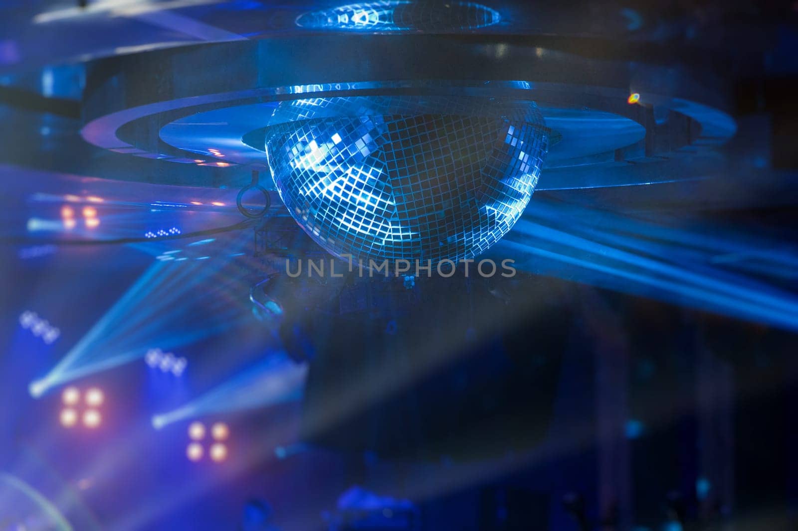 Disco ball with bright rays, night party or concert background