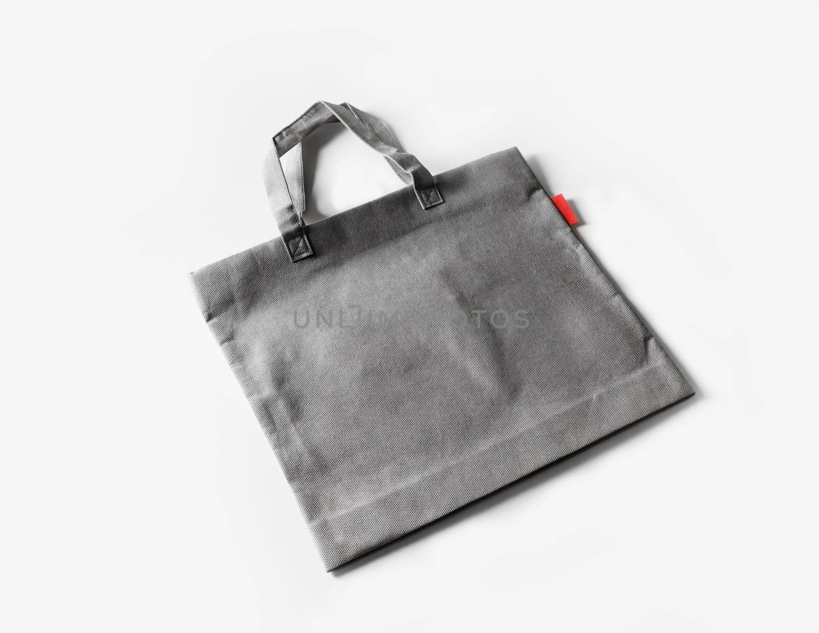 Blank gray shopping canvas bag on white paper background.