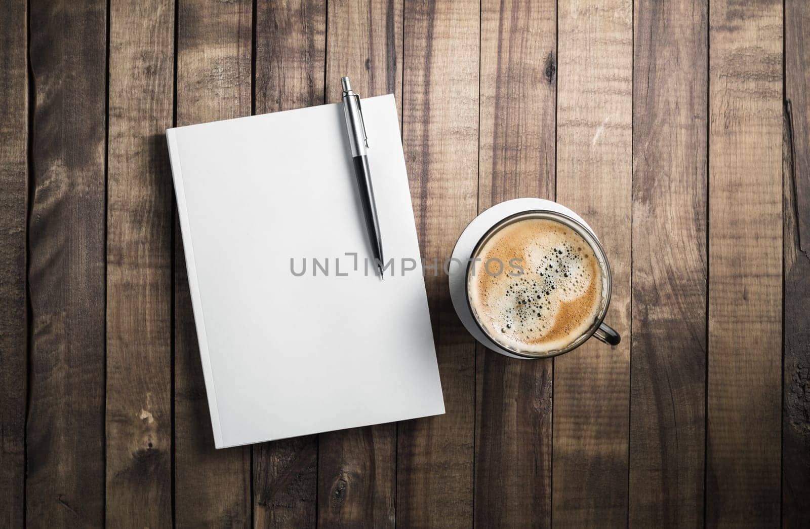 Blank book, pencil and coffee cup on wooden table background. Stationery elements. Template for placing your design.
