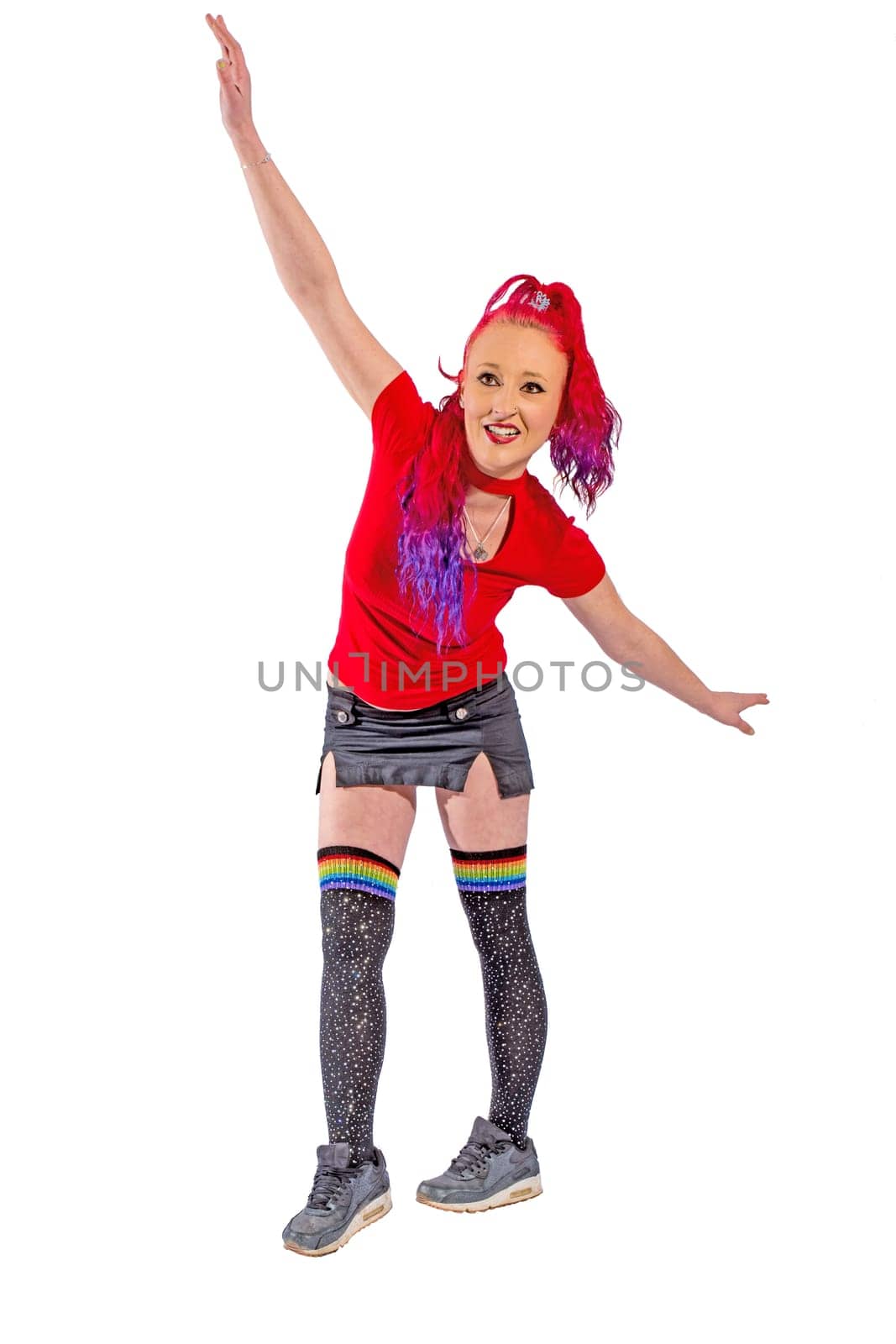 Woman with red hair and red shirt balances and stretches out her arms