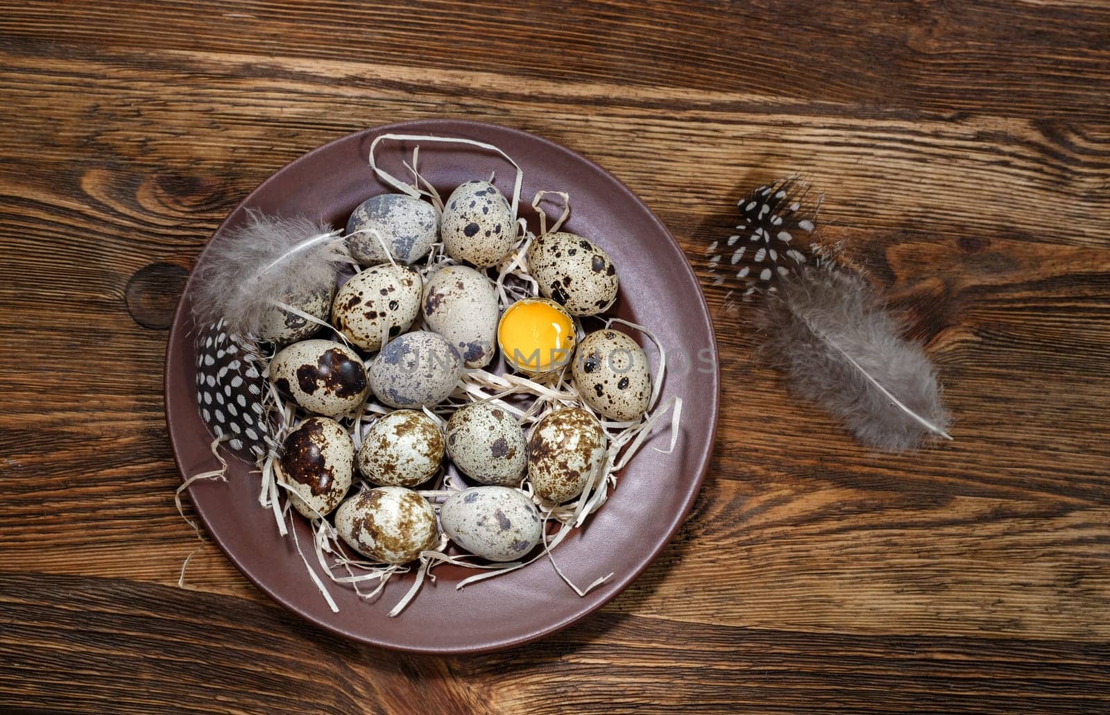 fresh quail eggs in a plate on a wooden background