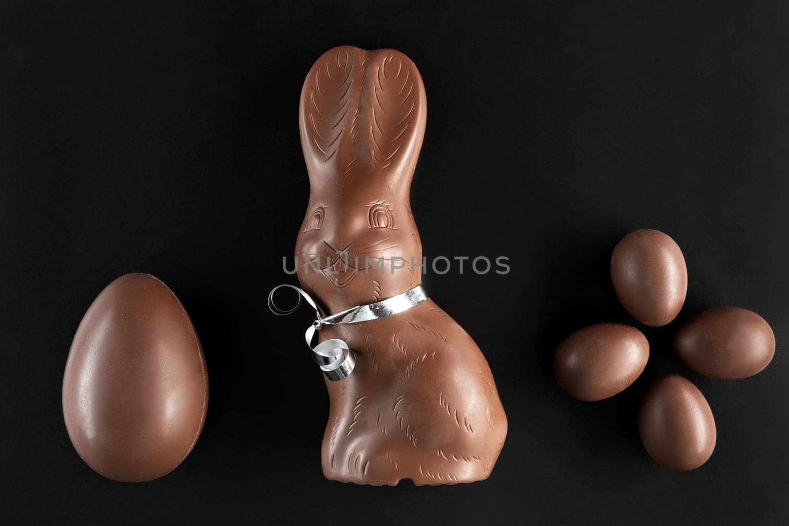 Delicious chocolate Easter bunny and eggs on dark background