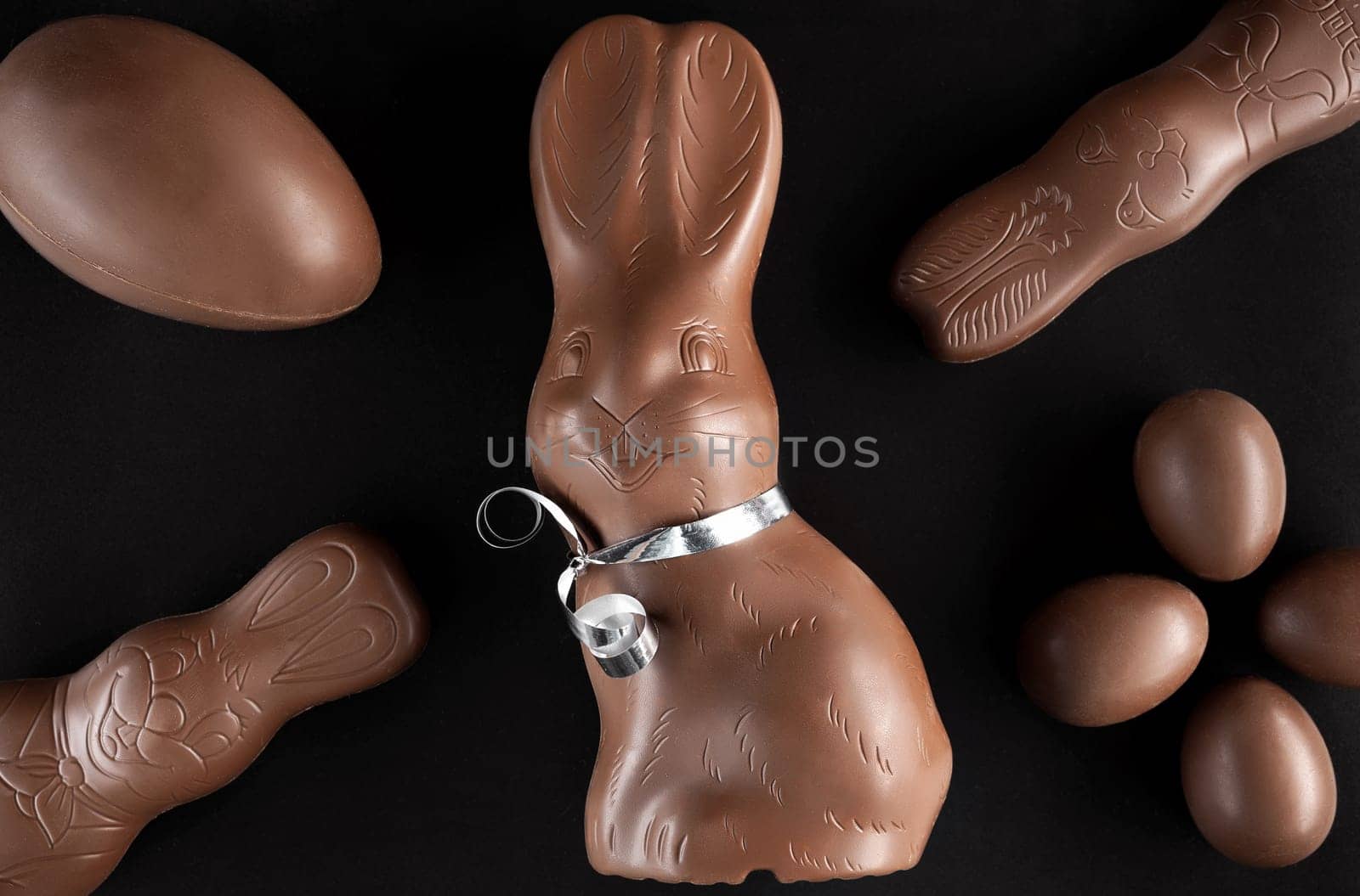 Delicious chocolate Easter bunny and eggs on dark background