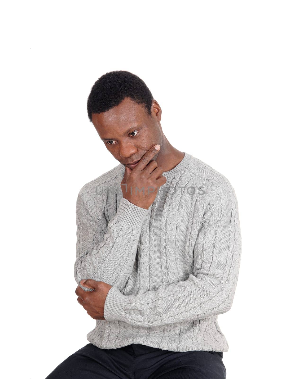 A close up image on a African American man in a gray sweater sitting .on chair with his hand on the chin, isolated for white background.