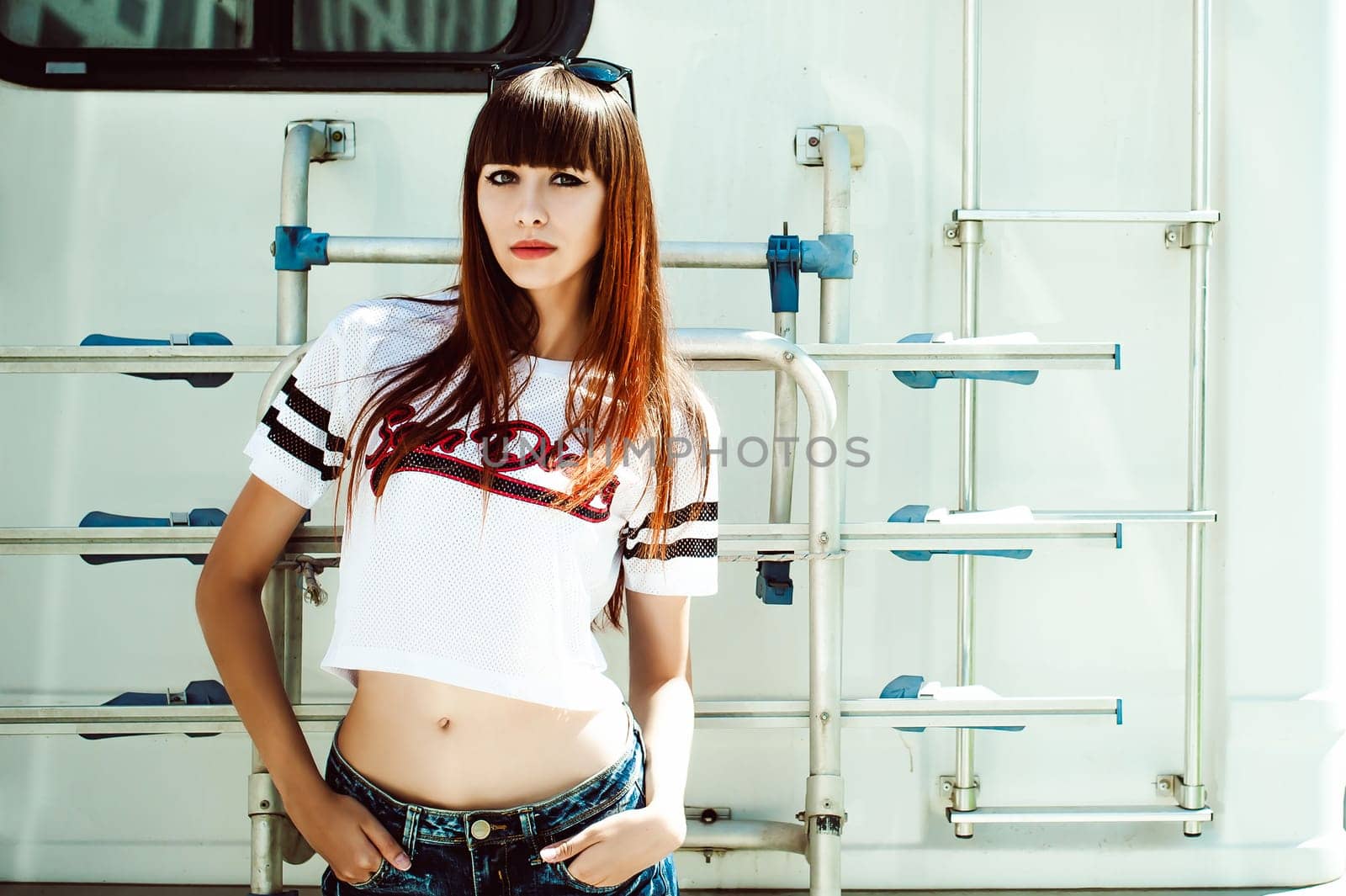 portrait attractive women in sports white T-shirt against background of Camper Trailer, transport for travel