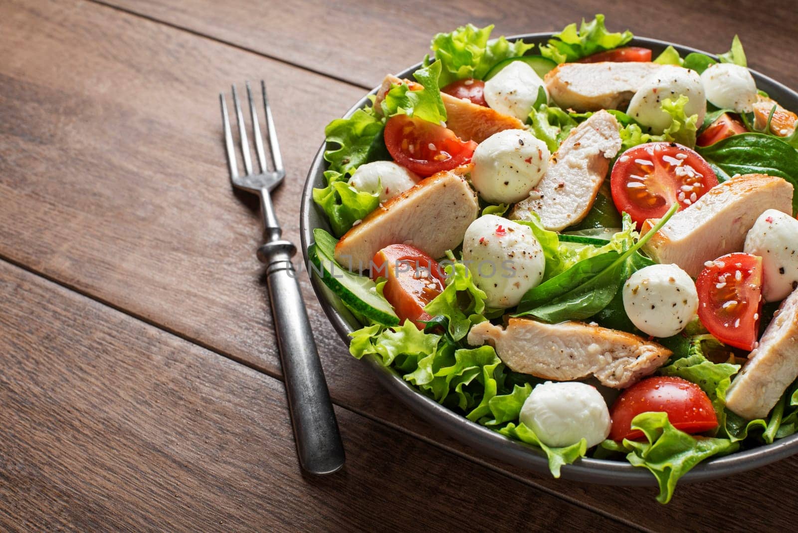 Fresh salad with chicken breast, mozzarella  and tomato. Top view
