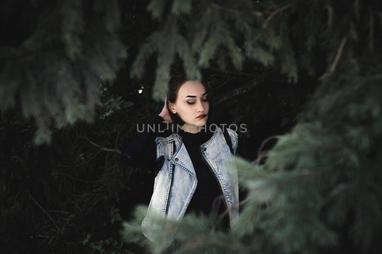 street portrait of a girl student, fashionably dressed in dark clothes, with a black backpack and denim jacket autumn sunny day
