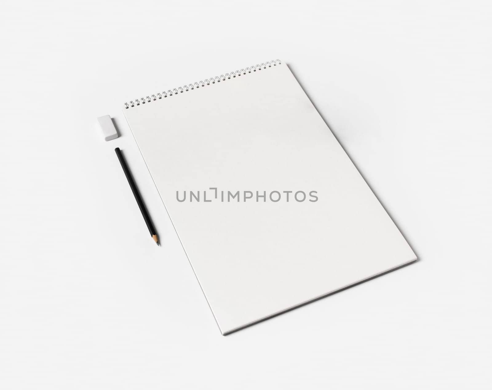 Blank notebook, pen and eraser on white paper background. Notepad and stationery.