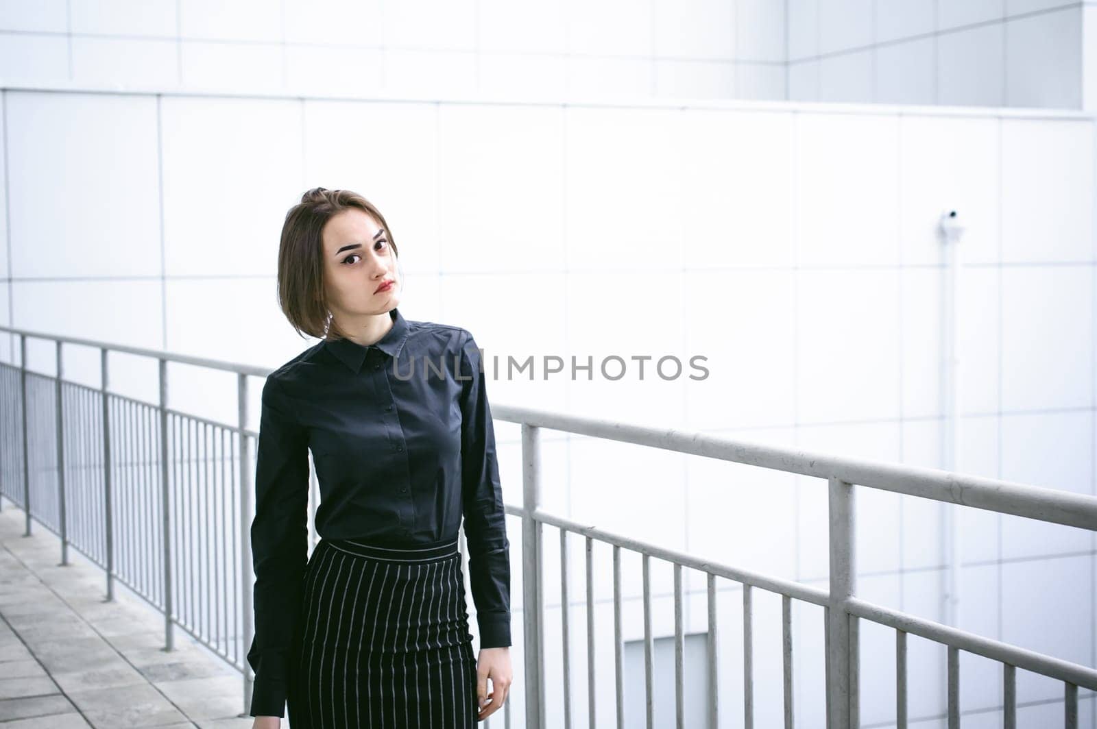 street portrait of a student girl dressed fashionably in dark clothes, on an autumn sunny day