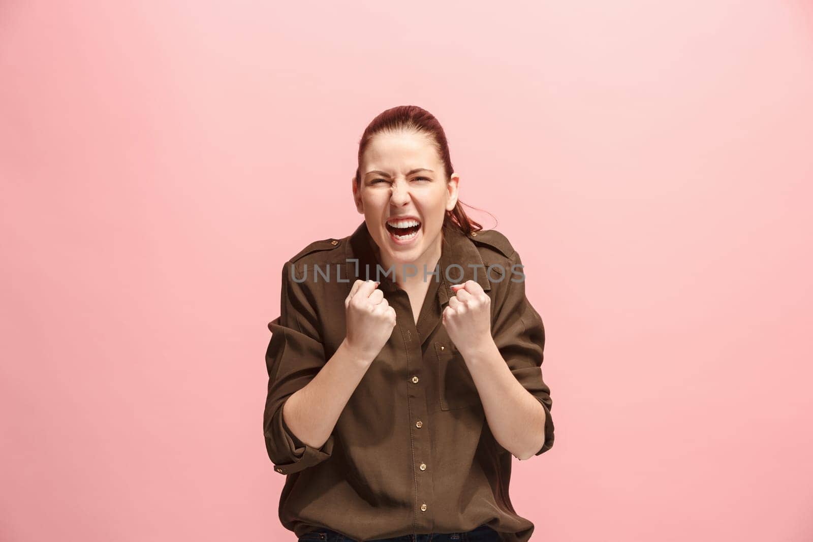 I won. Winning success happy woman celebrating being a winner. Dynamic image of caucasian female model on pink studio background. Victory, delight concept. Human facial emotions concept. Trendy colors