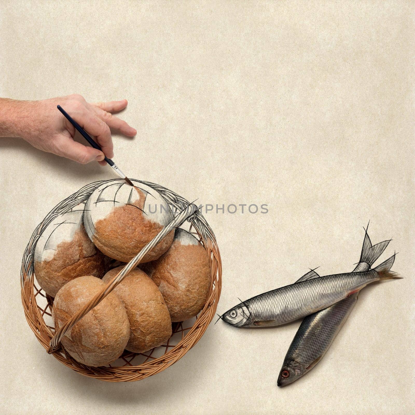 Hand painting over a drawing of five loaves of bread and two fish. Christian concept about preparing a bible study or a message on this.