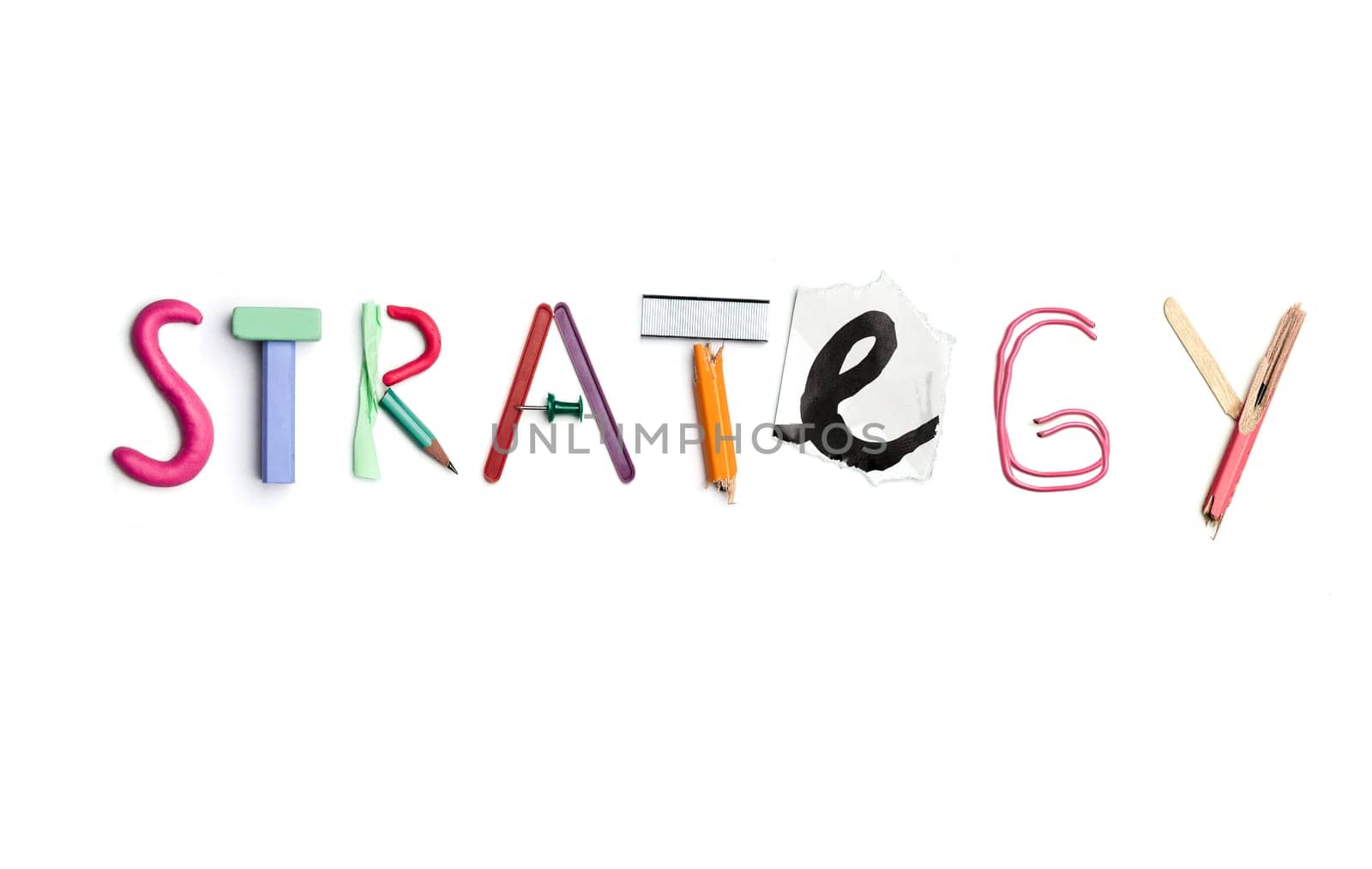 Concept of idea with colorful crumpled paper. The word strategy created from office stationery. The art, creative, letters concepts. Conceptual image. Top view, isolated on white desk. Work tool concept
