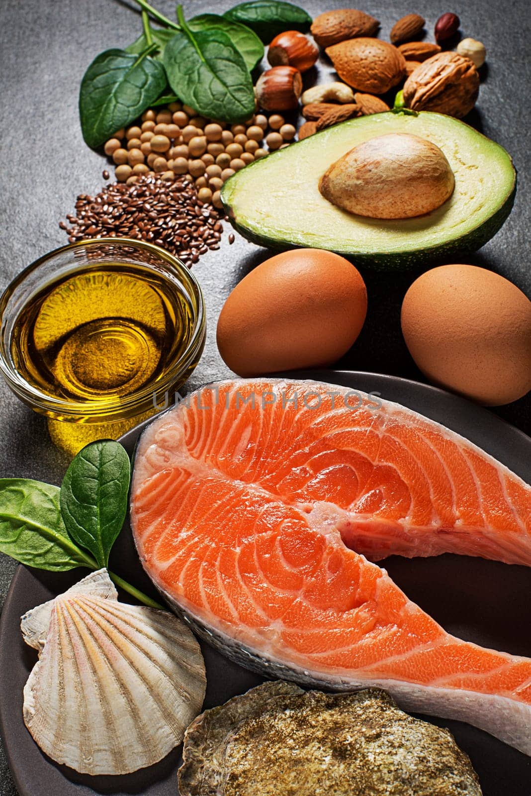 Selection of healthy fat food. Raw steak of salmon with fresh ingredients with high-fat benefits