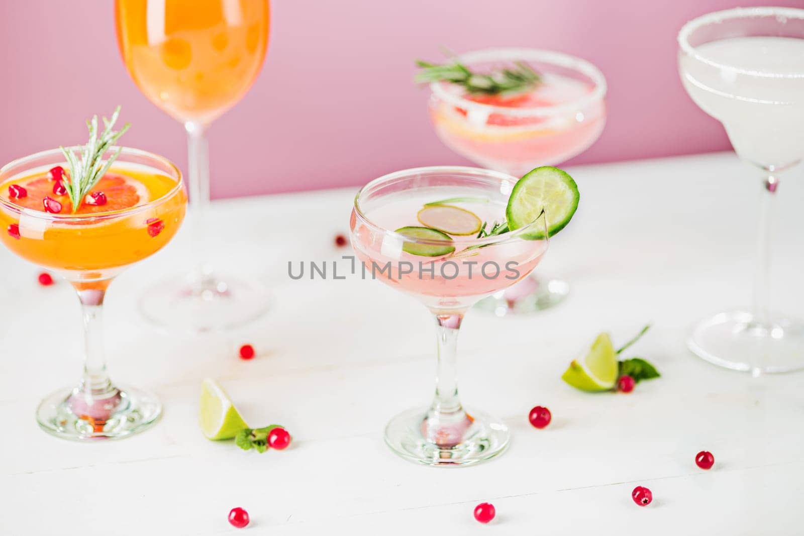 The rose exotic cocktails and fruits on table, against pink