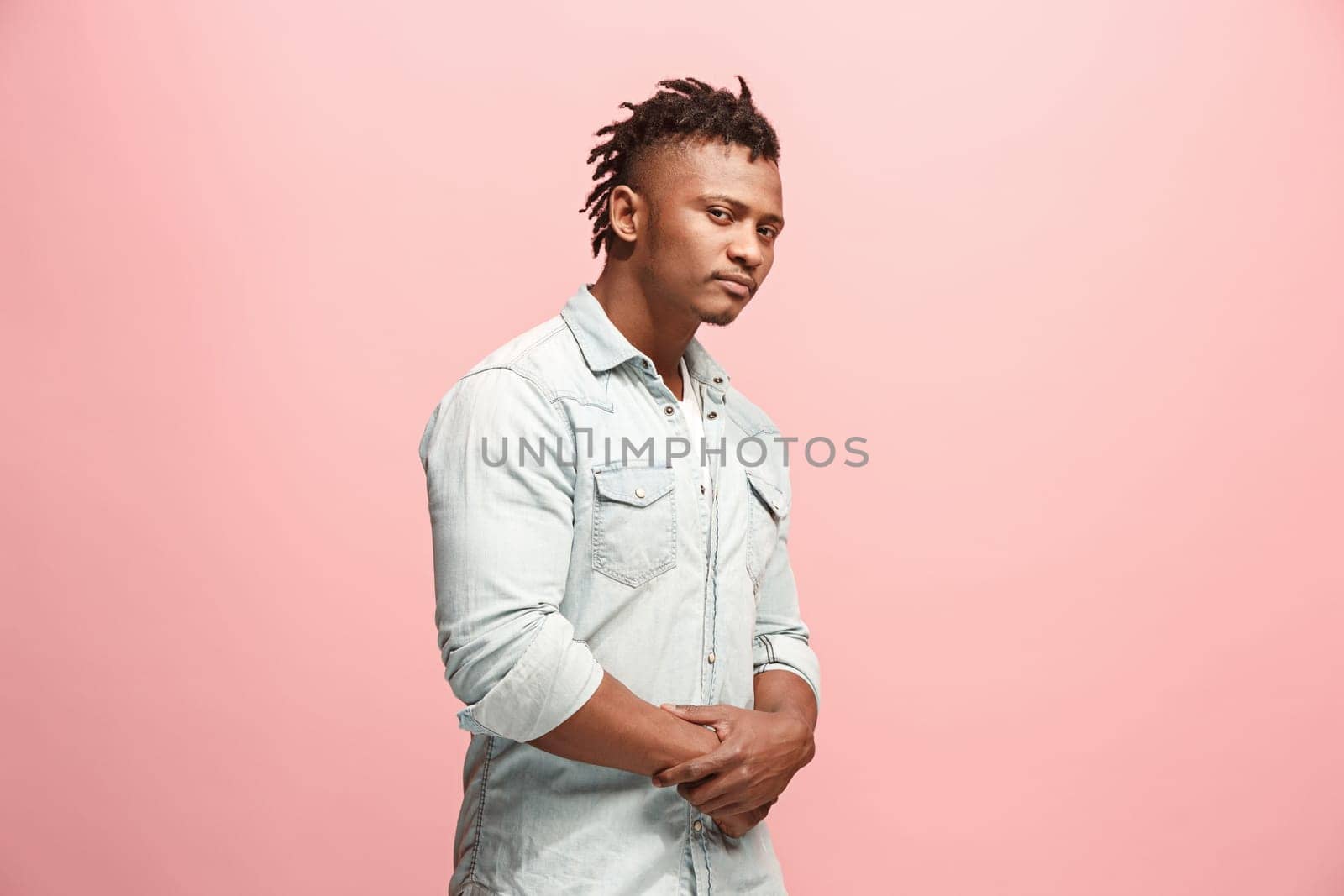 Suspicion. Doubt, mistrust, distrust concept. Doubtful afro man looking with disbelief expression . Young emotional man. Human emotions, facial expression concept. Studio. Isolated on trendy pink