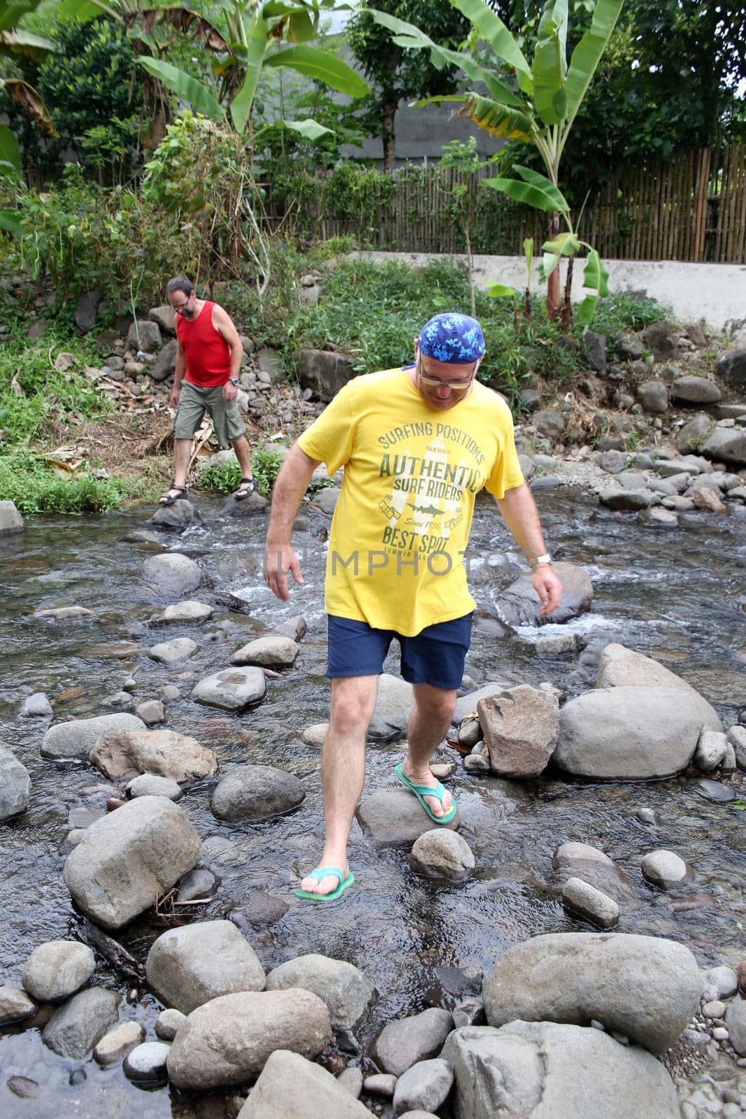 Tourists cross a stream over stones in the water,Pintuyan,Panaon Island,Southern Leyte,Philippines