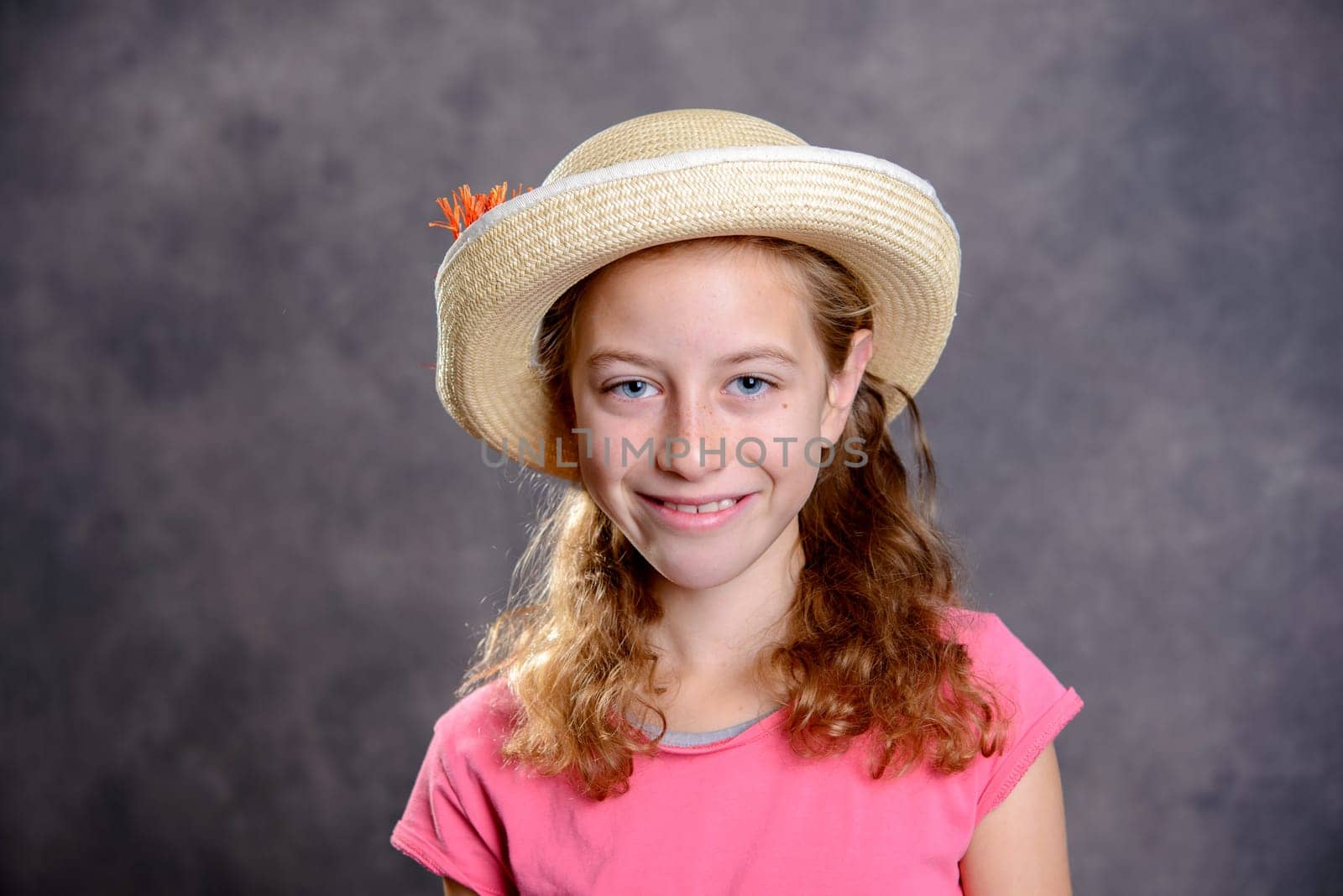 nice girl with blond hair in pink shirt and straw hat