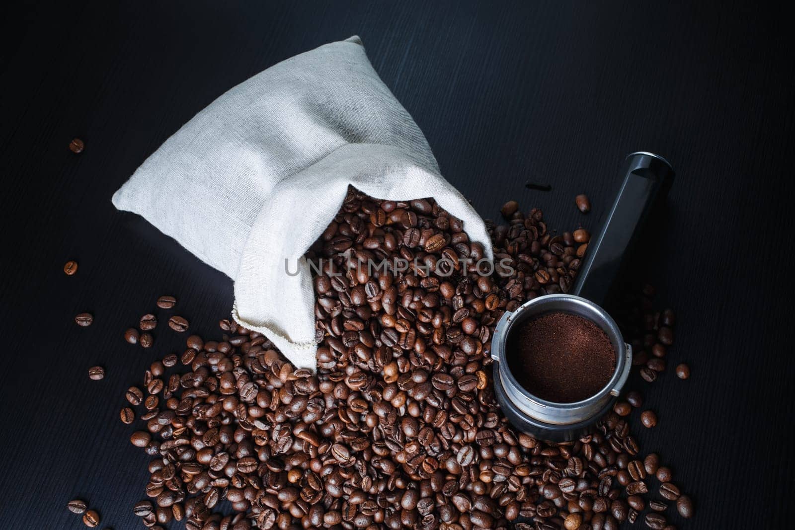 Coffee beans and holder from an espresso machine on kitchen table.