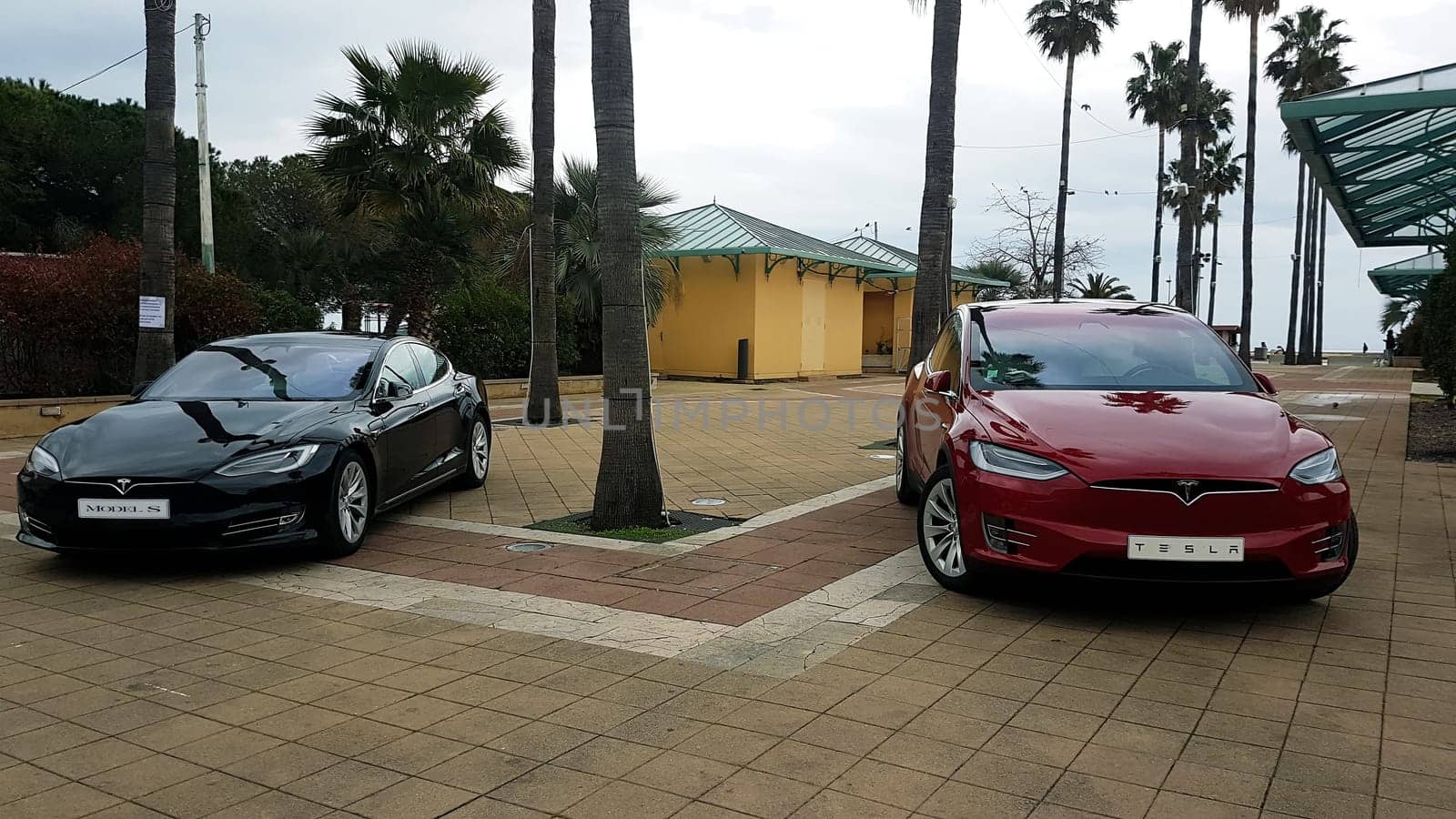 Menton, France - March 3, 2018: Luxury Black Tesla Model S And Red Tesla Model X Electric Cars Parked on a Square in Menton on The French Riviera