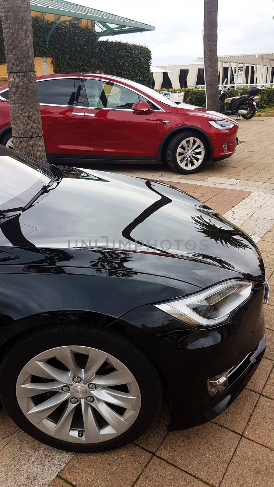 Menton, France - March 3, 2018: Luxury Black Tesla Model S And Red Tesla Model X Electric Cars Parked on a Square in Menton on The French Riviera