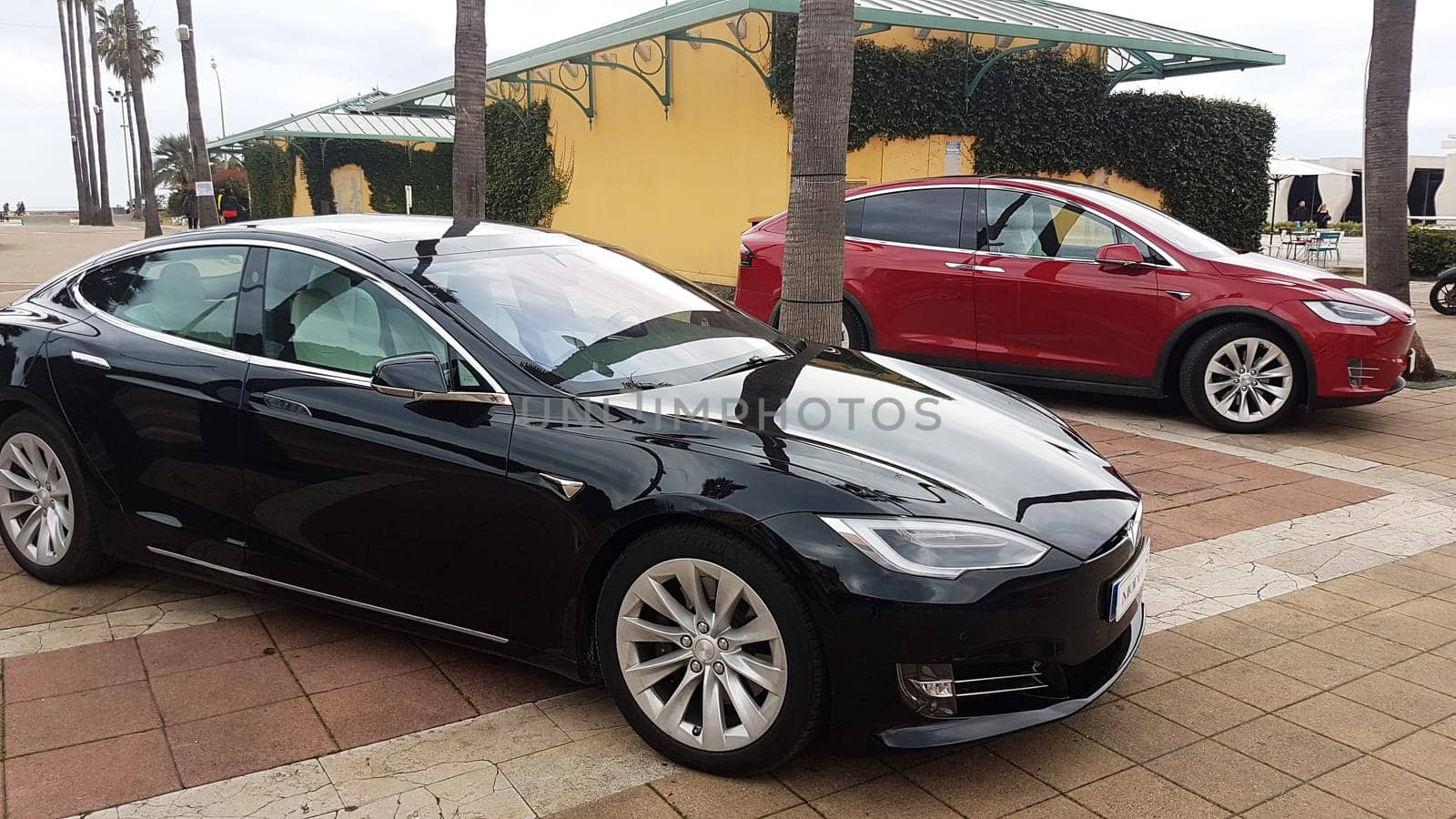 Menton, France - March 3, 2018: Luxury Black Tesla Model S And Red Tesla Model X Electric Cars Parked on a Square in Menton on The French Riviera.