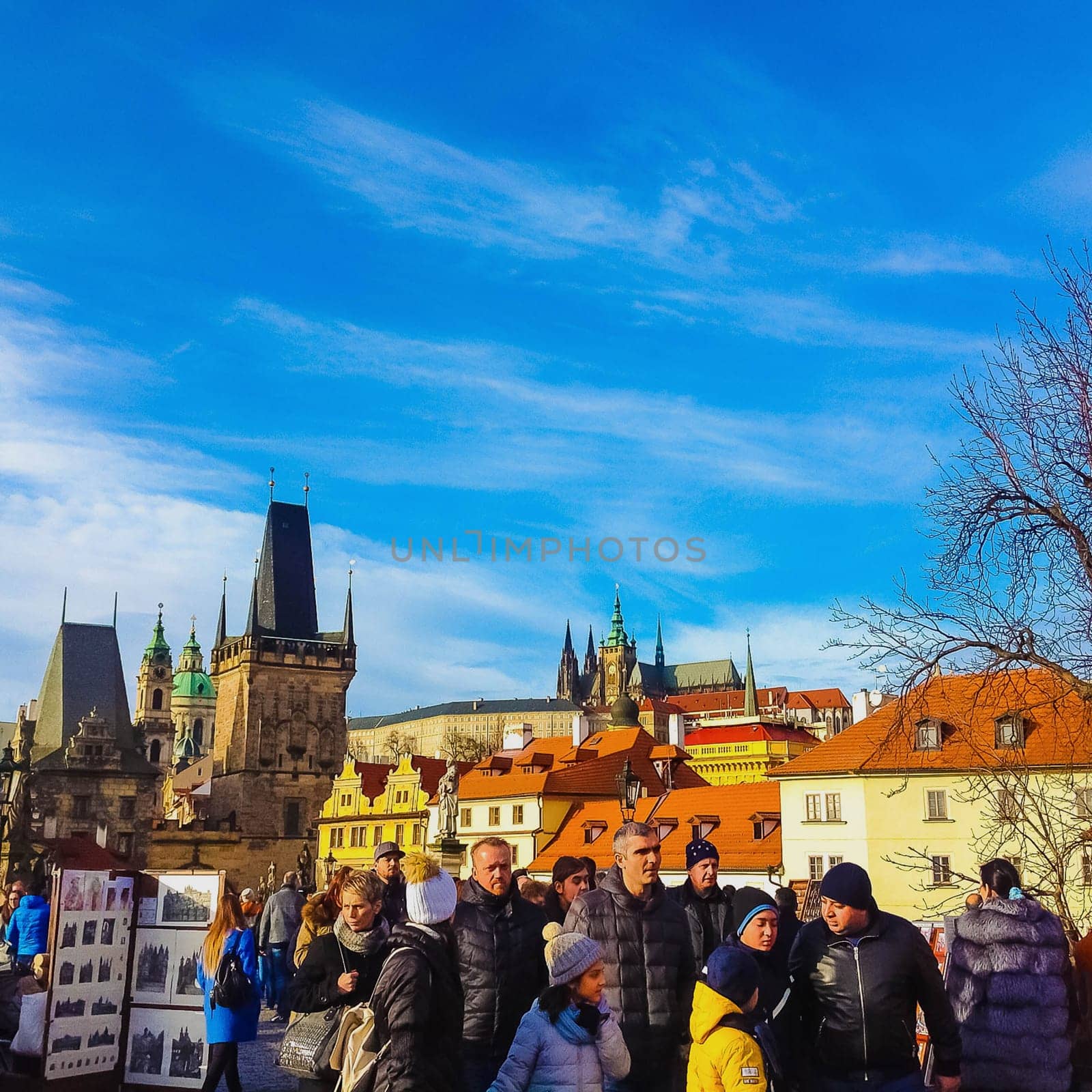 Prague, Czech Republic - December 31, 2017: People walking on the historic Charles Bridge that crosses the Vltava river overlooking its entrance tower.