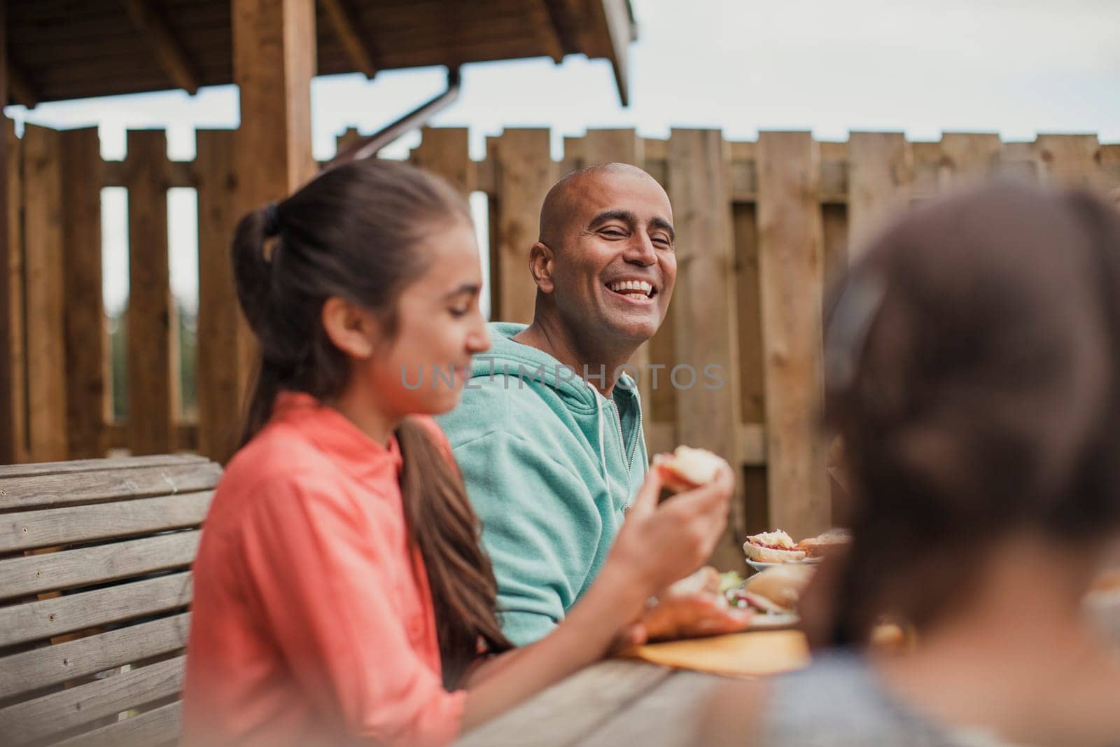 Father laughing at his daughters during brunch.