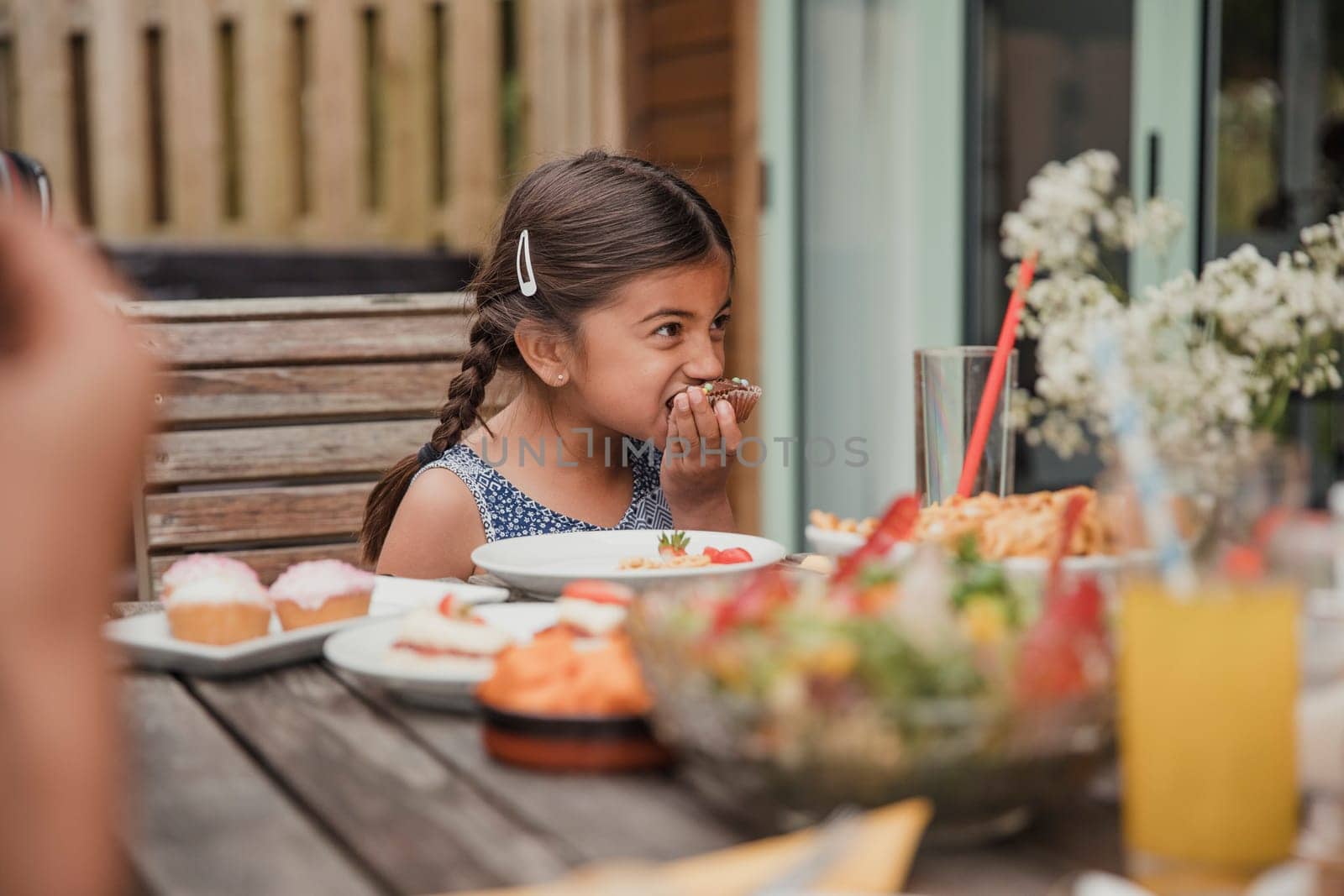 Surface level view of a little girl enjoying a chocolate cupcake.