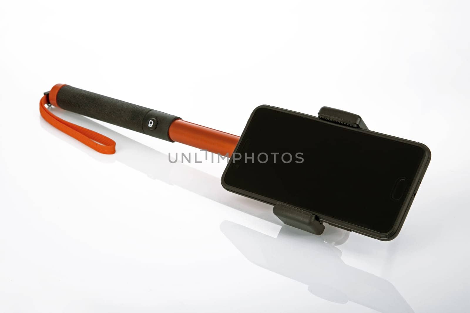 Selfie stick with smartphone on a bright background