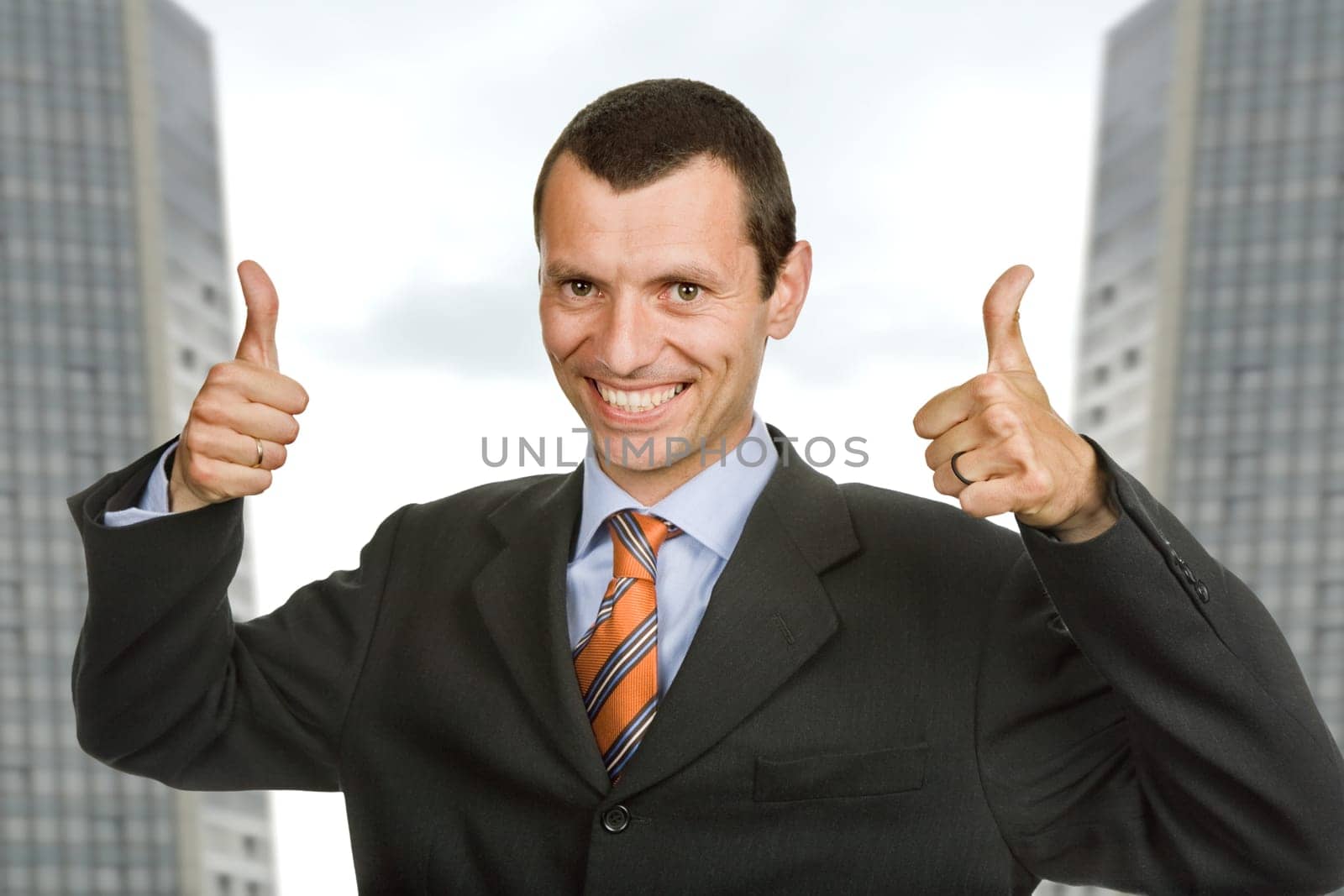 Young happy business man showing thumbs up