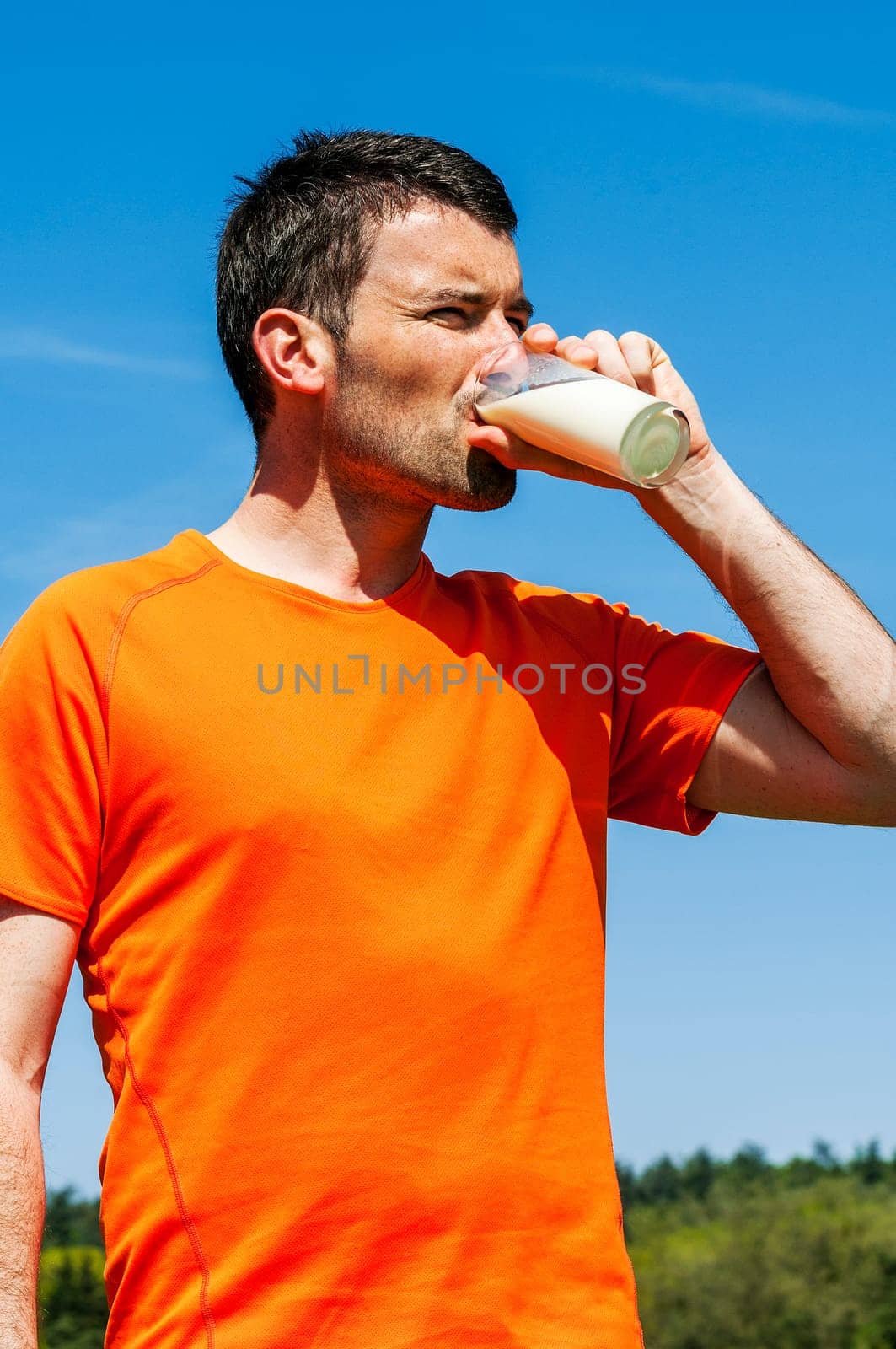 man is drinking fresh glass of milk in the blue skye