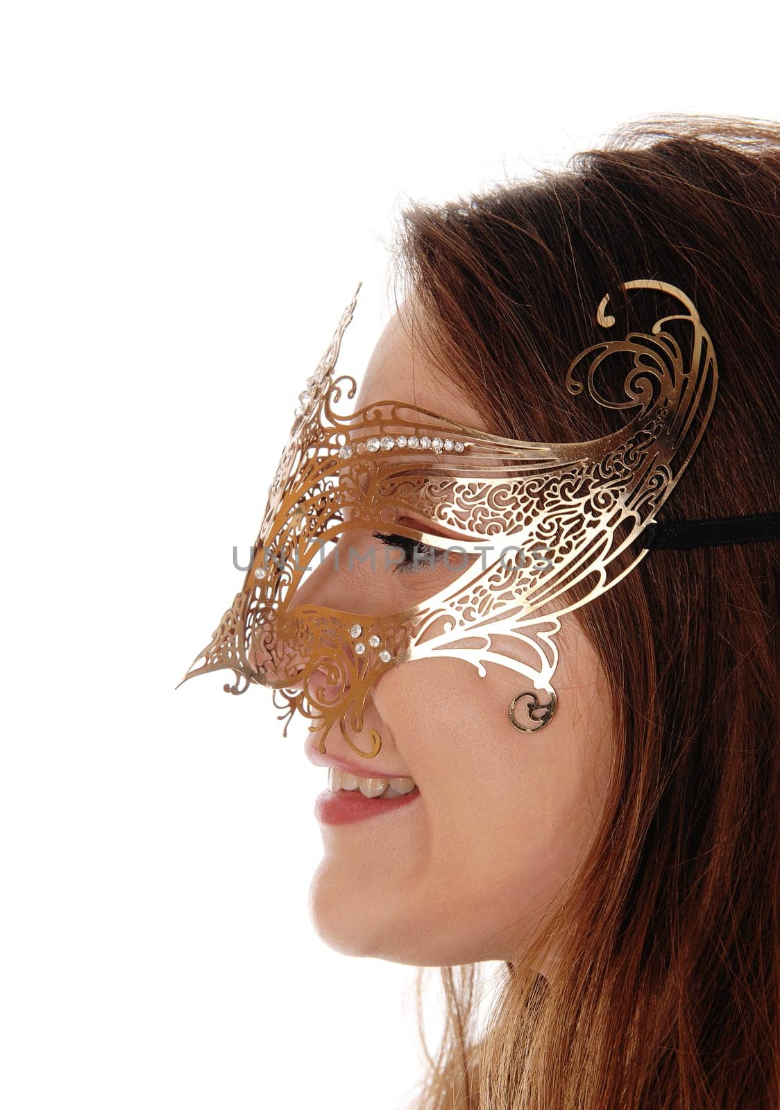 A head shot of a young gorgeous woman with long brunette hair.wearing a gold mask on her face, isolated for white background.