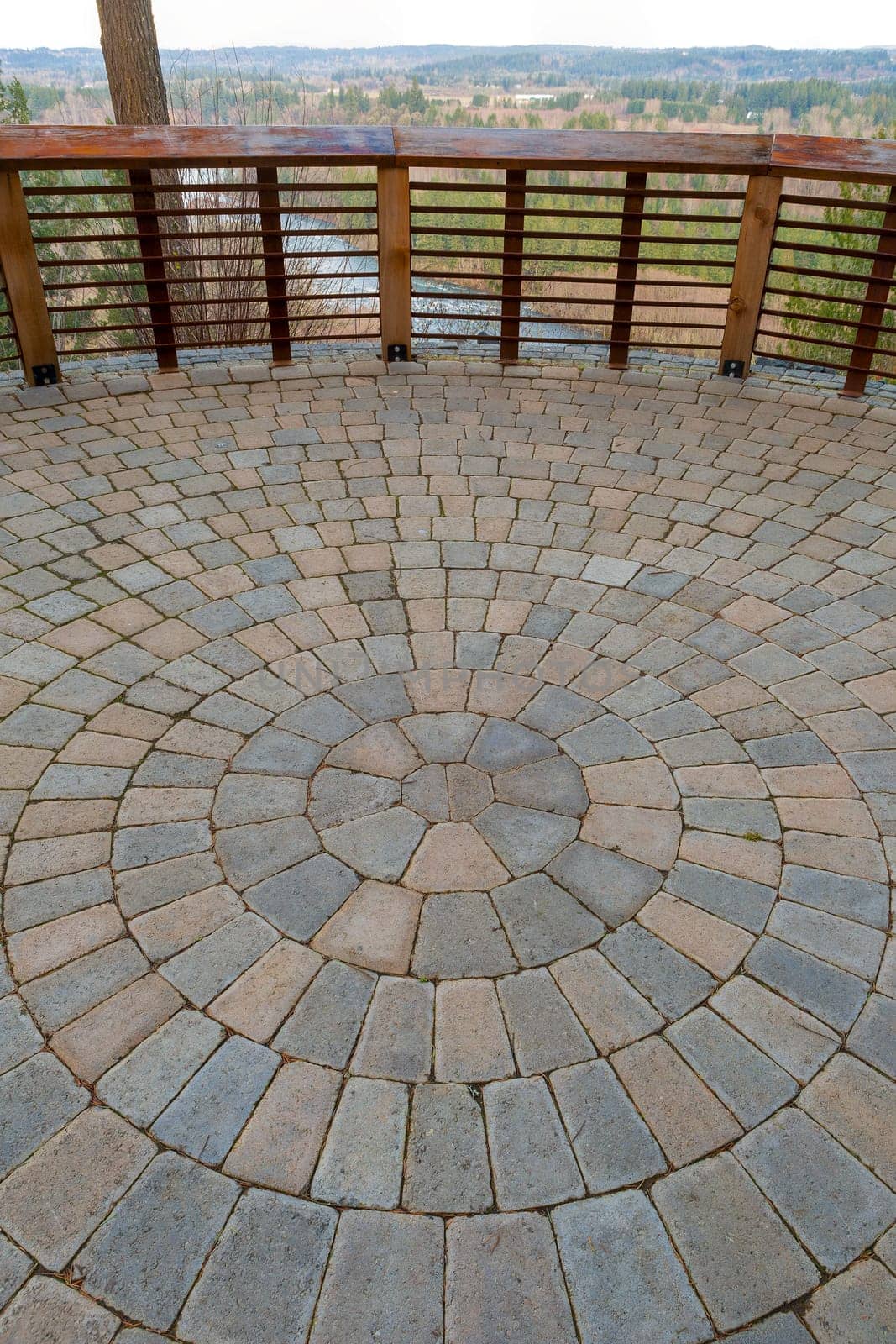 Garden Backyard circular brick stone pavers hardscape patio with wood railings stone wall view deck