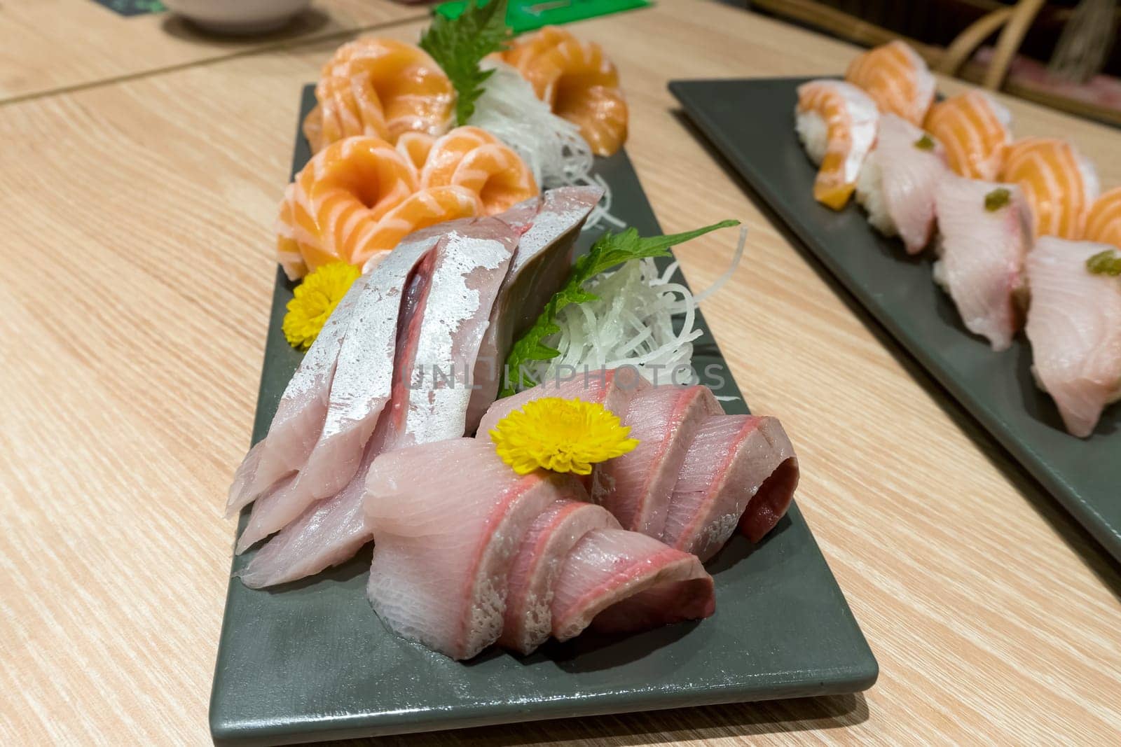 Fresh raw fish Japanese sushi sashimi plate with fatty tuna salmon yellowtail on ceramic plate closeup macro
