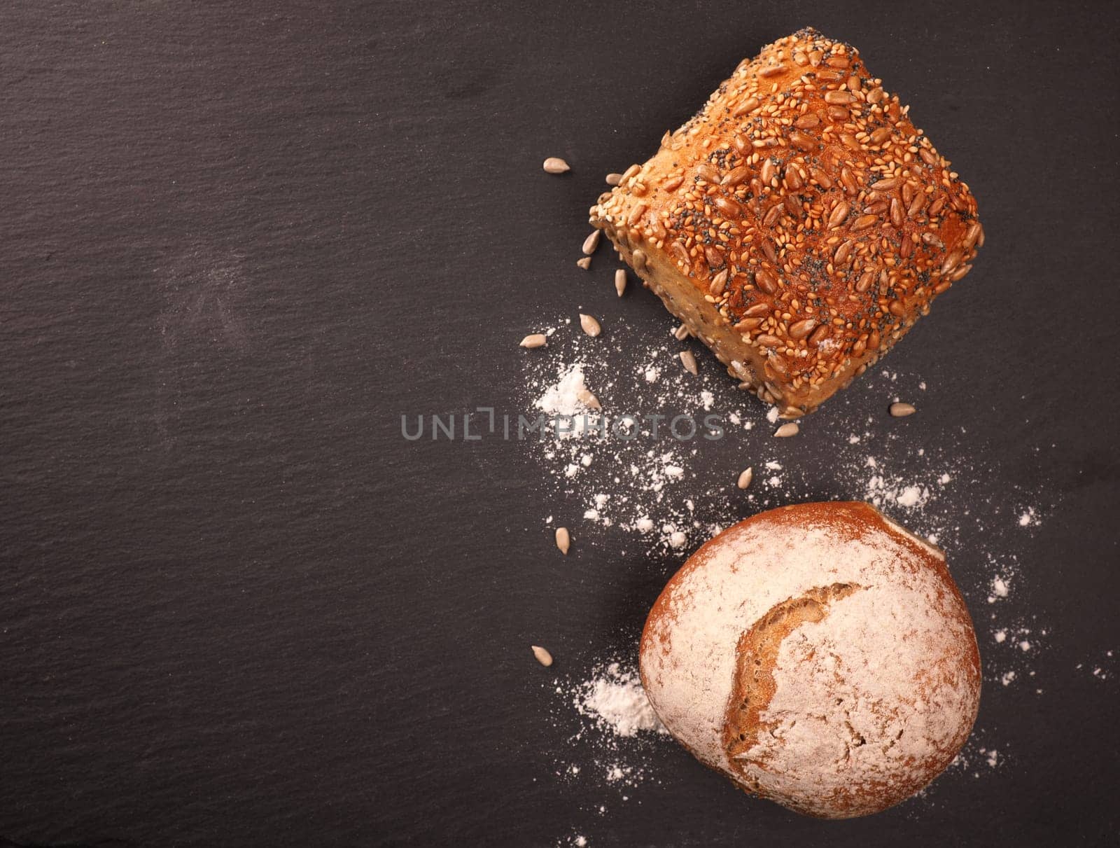 Tasty organic rolls on a dark slate cutting board, natural healthy eating